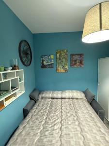 ein Schlafzimmer mit einem großen Bett und blauen Wänden in der Unterkunft Collis Iani - Experience in Colliano