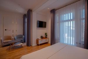 a bedroom with a bed and a chair and a television at Asal Boutique Hotel in Bukhara