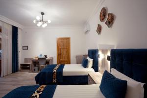 a hotel room with two beds and a table at Asal Boutique Hotel in Bukhara +90 photos