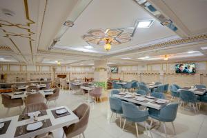 a dining room with tables and blue chairs at Asal Boutique Hotel in Bukhara