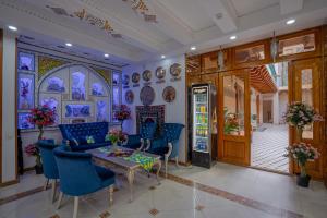 a dining room with blue chairs and a table at Asal Boutique Hotel in Bukhara