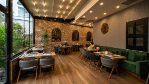 a restaurant with tables and chairs and people sitting at them at Ber Mai İnci Hotel Antalya in Antalya