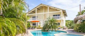 a villa with a swimming pool and a house at Wayaca Mini Resort in Willemstad