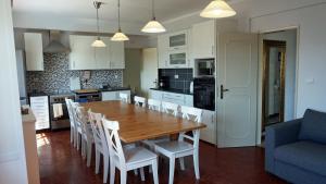 a kitchen and dining room with a wooden table and chairs at Casa Grande Holidays in São Martinho do Porto