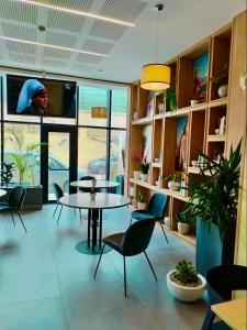 a room with a table and chairs and a tv at Le Yot Hotel in 'Aïn Benian