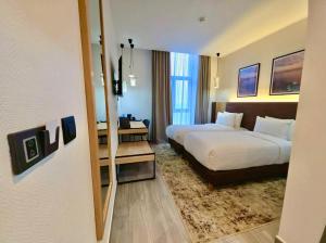 a hotel room with two beds and a desk at Le Yot Hotel in 'Aïn Benian +15 photos
