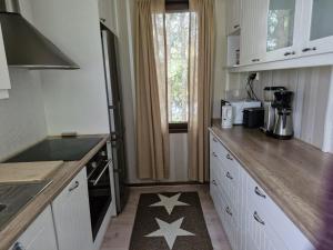 a kitchen with white cabinets and stars on the floor at Kolmio Kaurialassa in Hämeenlinna