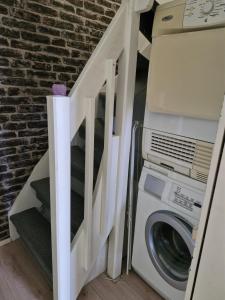 a laundry room with a washing machine and a staircase at Kolmio Kaurialassa in Hämeenlinna +1 photo