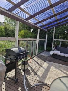 a grill on a deck with a pergola at Kolmio Kaurialassa in Hämeenlinna