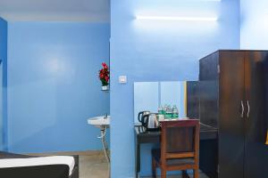 a blue room with a kitchen with a table and a chair at HOTEL O RAHAN APPARTMENT in New Town