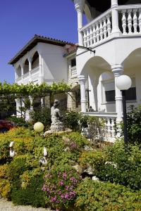 a large white house with a statue in front of it at Apartments Anamarija in Medulin