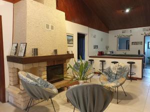 a living room with chairs and a fireplace at La baie rose in Sainte-Rose