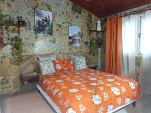 a bedroom with a bed and a stone wall at La baie rose in Sainte-Rose