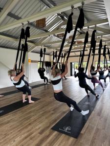 a group of people doing yoga in a gym at Lakeside Shepard's Hut 'Sanderling' in Bishampton