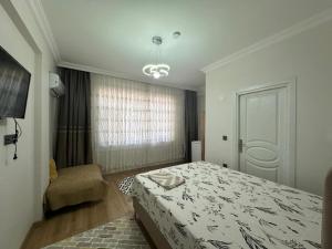 a bedroom with a bed and a chair and a window at Mürefte Suite in Tekirdağ