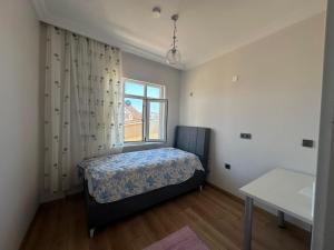 a small bedroom with a bed and a window at Mürefte Suite in Tekirdağ