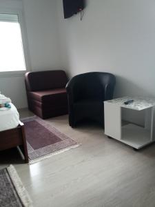 a living room with a black chair and a table at Harmonija in Palić