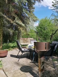 a patio with a grill and a table and chairs at Landidyll Am Eisenberg in Kirchberg