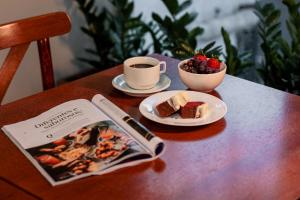 a table with a book and a plate of food and a cup of coffee at Hotel Évora by Rede Sagres in Florianópolis