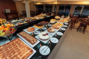 a buffet with many different types of food on a table at Hotel Évora by Rede Sagres in Florianópolis