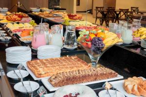 a buffet with many different types of food and drinks at Hotel Évora by Rede Sagres in Florianópolis