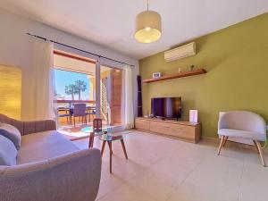a living room with a couch and a tv at Albatros Playa 3 - 3409 in Mar de Cristal