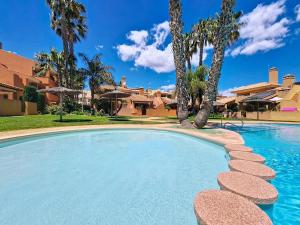 a swimming pool in a resort with palm trees at Albatros Playa 3 - 3409 in Mar de Cristal
