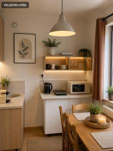 a kitchen with a table and a dining room at LaBONI Apartman in Miskolctapolca