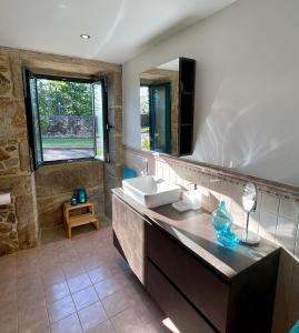 a bathroom with a sink and a mirror at Casa Rural A Redondiña in Lamas