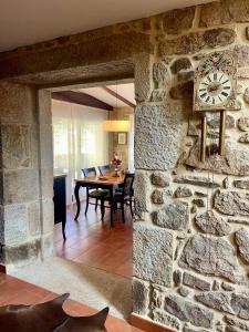 a room with a stone wall with a clock on it at Casa Rural A Redondiña in Lamas +53 photos