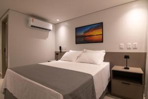 una camera da letto con un letto bianco e un quadro sulla parete di Hotel Mandu a Teresina