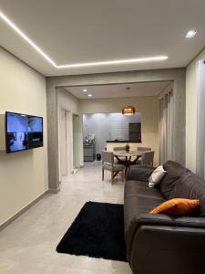a living room with a couch and a dining room at Casa Nova, 2 quartos, 1 Ar-Cond, 1 Banheiro, Garagem 4,30m in Montes Claros