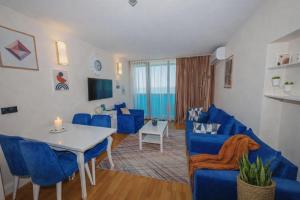 a living room with blue chairs and a table at Panorama ORBI CITY LUXURY in Batumi