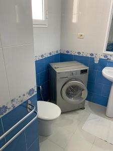a bathroom with a washing machine and a toilet at Villa dhiefa avec piscine in Temlale +18 photos