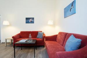 a living room with two red couches and a coffee table at Gut Staberhof Staberwind in Staberdorf