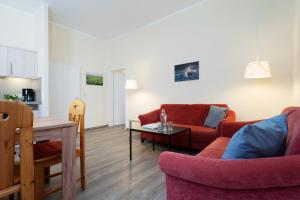 a living room with two red couches and a table at Gut Staberhof Staberwind in Staberdorf