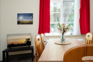 a dining room table with a vase of flowers on it at Gut Staberhof Staberwind in Staberdorf