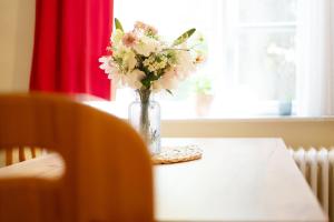 a vase of flowers on a table with a window at Gut Staberhof Staberwind in Staberdorf +15 photos