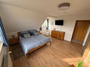 a bedroom with a bed and a flat screen tv at Ostseekoje Koje 4 in Süssau