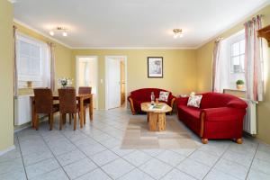 a living room with two red couches and a table at Dorfstraße 28 Seeadler in Klausdorf
