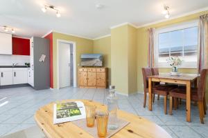 a living room with a table and a kitchen at Dorfstraße 28 Seeadler in Klausdorf +17 photos
