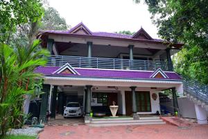 a house with a car parked in front of it at Harbour villa 1 in Trivandrum