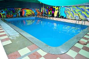 a swimming pool with graffiti on the side of a building at Harbour villa 1 in Trivandrum +15 photos