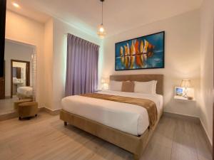 a bedroom with a bed and a painting on the wall at Playa Palmera Beach Resort in Punta Cana +50 photos