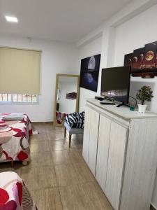 a living room with a tv on a dresser with a bed at Seven Hotel - Juana Koslay San Luis in Juana Koslay 