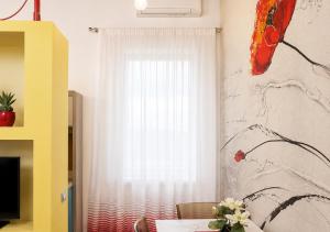 a room with a window with a table and a white curtain at L'Abbraccio in Tivoli