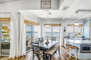 a kitchen and dining room with a table and chairs and the ocean at CJ286FLR LUX-Parrotfish Point in Cudjoe Key