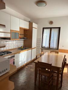 a kitchen with a wooden table and a table and chairs at Villa Angela in Dorio +52 photos