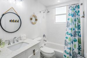a bathroom with a sink and a toilet and a mirror at CJ286FLR LUX-Parrotfish Point in Cudjoe Key +33 photos