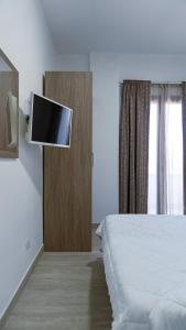 a bedroom with a bed and a flat screen tv at Kalispera Rooms in Scalea